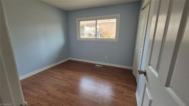 spare room featuring dark wood-type flooring