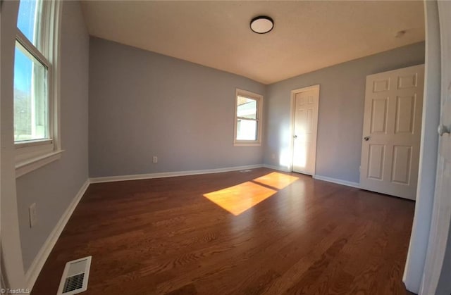 spare room with dark wood-type flooring
