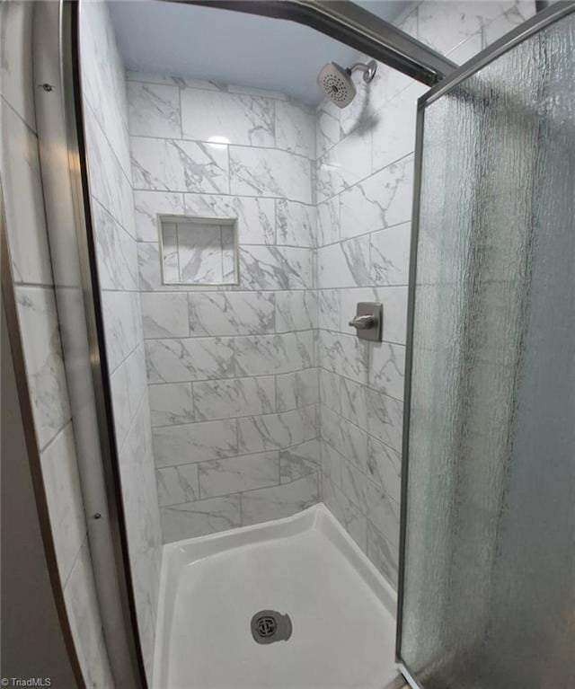 bathroom with a shower with door