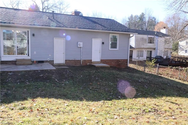 back of property with a lawn and a patio