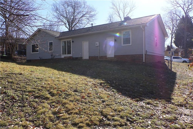 rear view of house featuring a lawn
