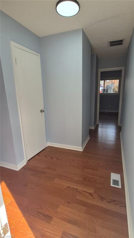 hallway with dark hardwood / wood-style floors