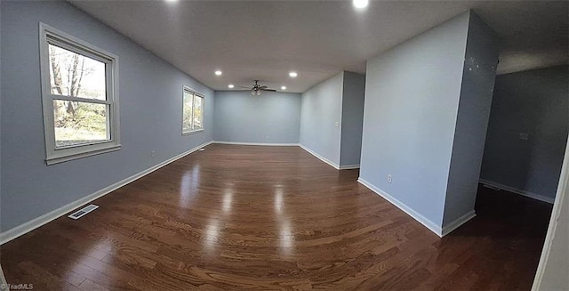 unfurnished room featuring ceiling fan and dark wood-type flooring
