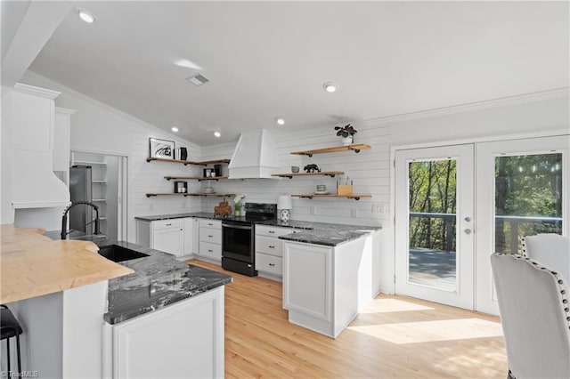 kitchen with custom range hood, vaulted ceiling, sink, black range with electric cooktop, and kitchen peninsula