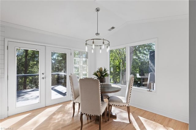 dining space with ornamental molding, vaulted ceiling, french doors, and light hardwood / wood-style floors