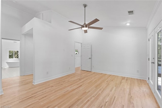 spare room with crown molding, a wealth of natural light, and light hardwood / wood-style floors