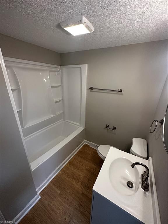 full bathroom featuring a textured ceiling, hardwood / wood-style flooring, vanity, and toilet