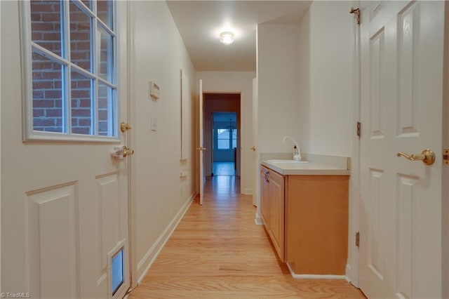 hall featuring light wood-type flooring and sink