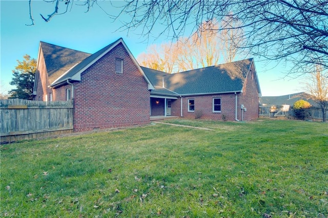 rear view of house featuring a yard