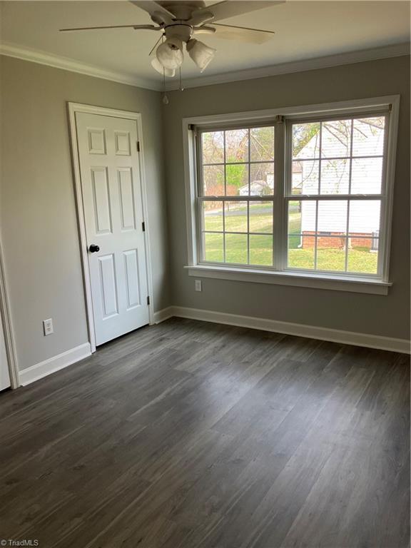 120 King Arthur Dr, King, NC 27021 - spare room featuring baseboards, ornamental molding, ceiling fan, and dark wood-type flooring
