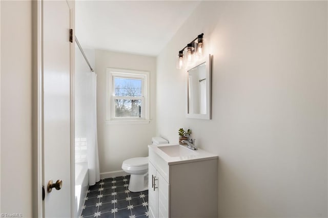 bathroom with vanity, toilet, shower / bath combo, and baseboards