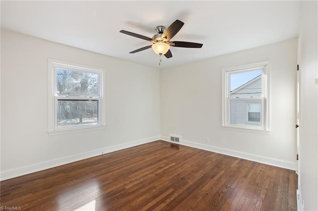 unfurnished room featuring visible vents, ceiling fan, dark wood-type flooring, and baseboards