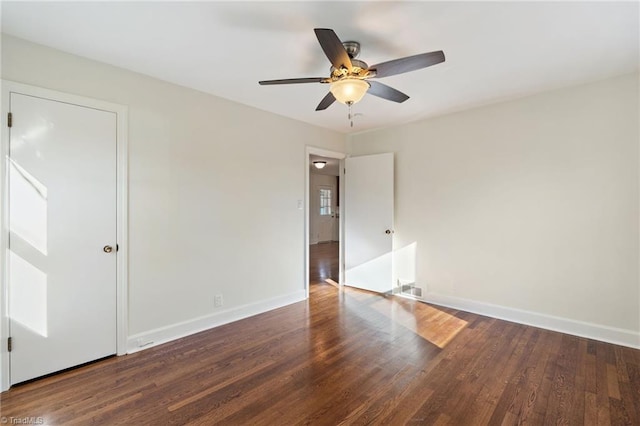 unfurnished room with baseboards, wood finished floors, and a ceiling fan