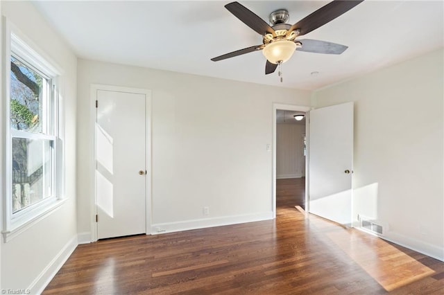 spare room with visible vents, baseboards, and wood finished floors