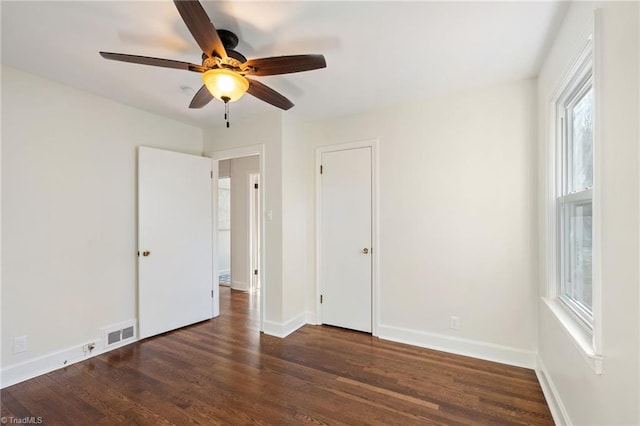 unfurnished bedroom with ceiling fan, wood finished floors, visible vents, and baseboards