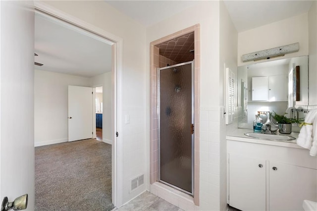 full bath featuring visible vents, vanity, and a shower stall