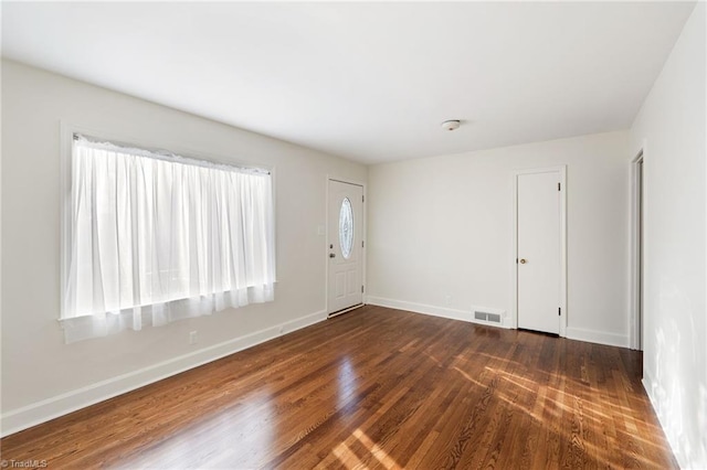 entrance foyer with visible vents, baseboards, and dark wood-style flooring