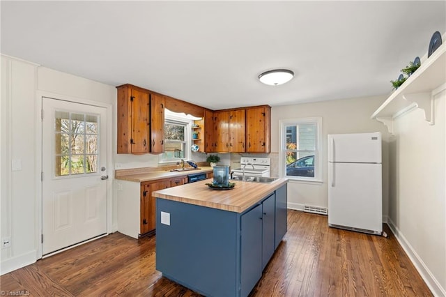 kitchen featuring blue cabinets, wood counters, freestanding refrigerator, brown cabinetry, and dark wood-style flooring