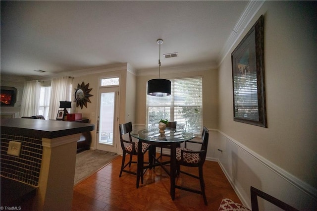 dining room with dark hardwood / wood-style flooring and ornamental molding