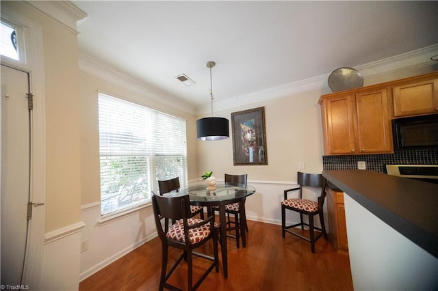 dining room featuring dark hardwood / wood-style flooring and ornamental molding