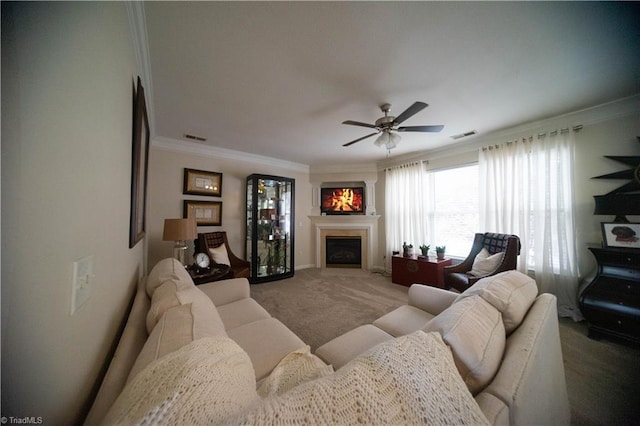 carpeted living room featuring ornamental molding and ceiling fan