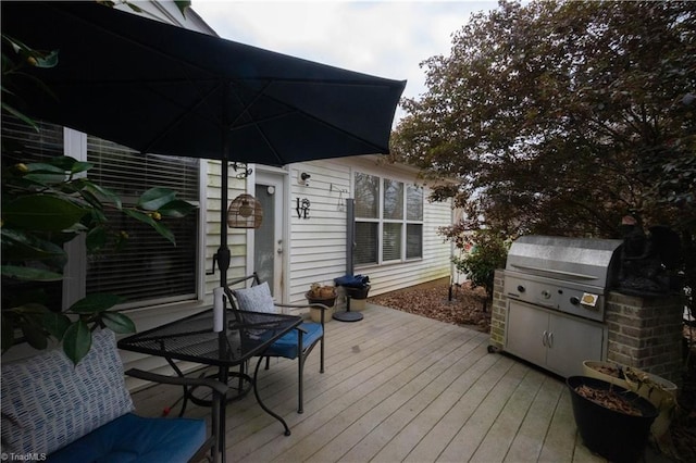 wooden deck with an outdoor kitchen and a grill