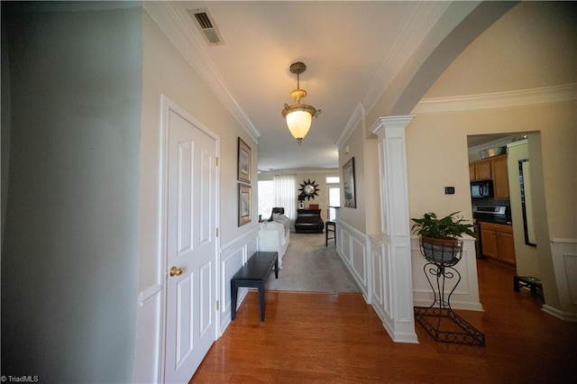 hall featuring crown molding, hardwood / wood-style flooring, and ornate columns