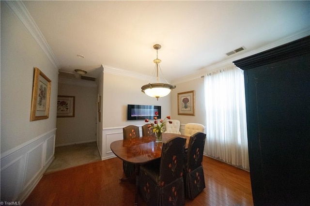 dining area featuring crown molding and hardwood / wood-style flooring