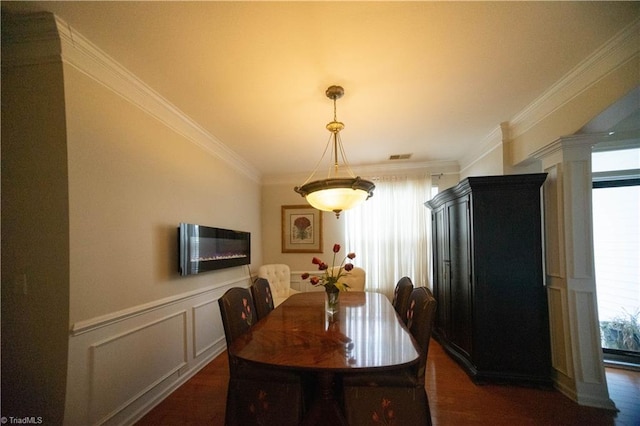 dining space with dark hardwood / wood-style flooring, ornamental molding, and ornate columns