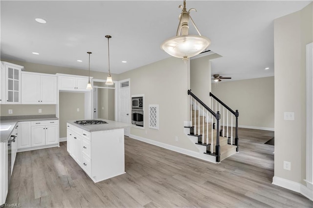 2101 Abbott Dr, Greensboro, NC 27455 - kitchen featuring stainless steel appliances, ceiling fan, glass insert cabinets, light wood-style floors, and a kitchen island