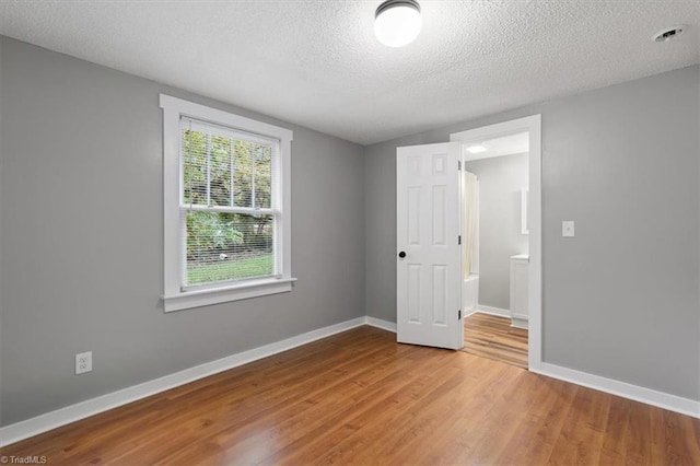 unfurnished bedroom with hardwood / wood-style floors and a textured ceiling