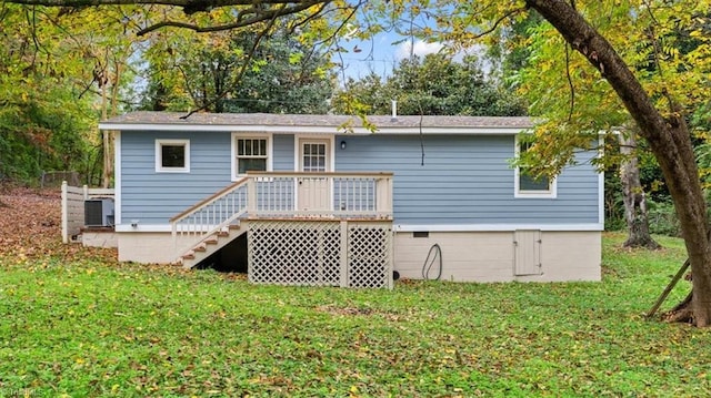 rear view of house featuring a wooden deck, a lawn, and central AC