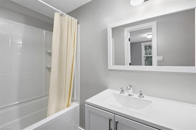 bathroom featuring vanity, shower / bath combo with shower curtain, and a textured ceiling