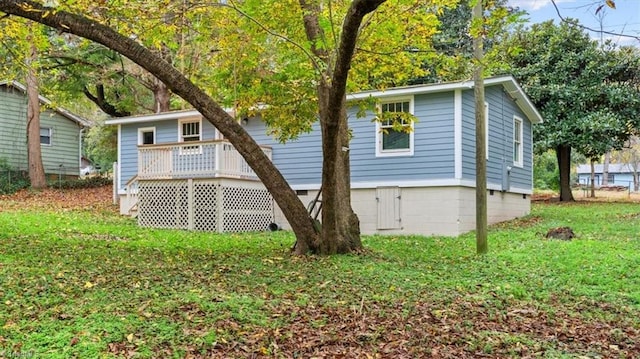 view of home's exterior with a deck and a lawn