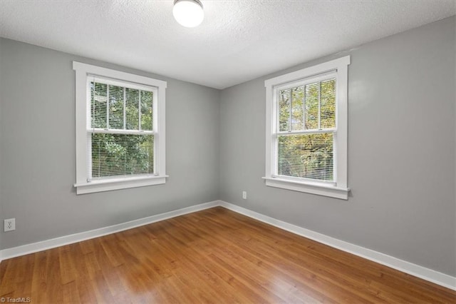 spare room featuring hardwood / wood-style floors and a textured ceiling