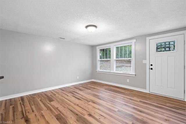 foyer entrance featuring hardwood / wood-style floors and a textured ceiling