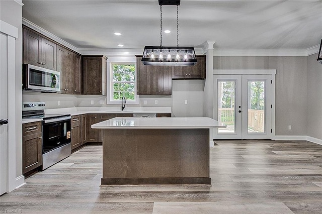4503 Holly Leaf Rd, Ramseur, NC 27316 - kitchen featuring appliances with stainless steel finishes, crown molding, dark brown cabinets, light wood-style flooring, and a sink