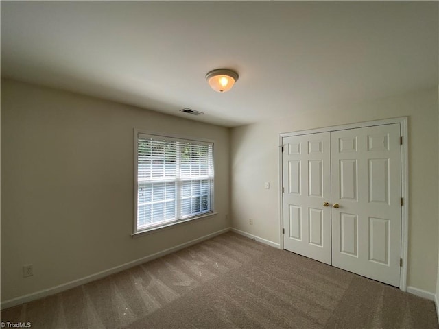 unfurnished bedroom featuring a closet and carpet flooring