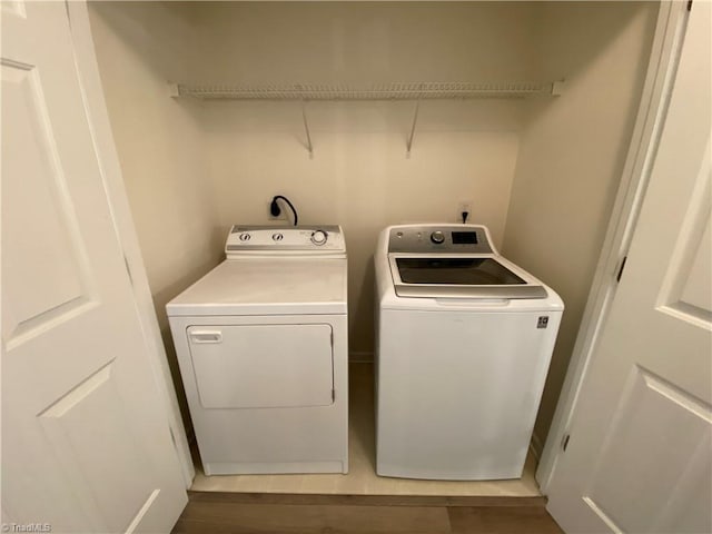 washroom featuring dark wood-type flooring and washer and clothes dryer