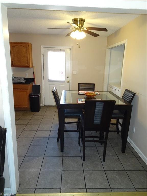 tiled dining space featuring ceiling fan