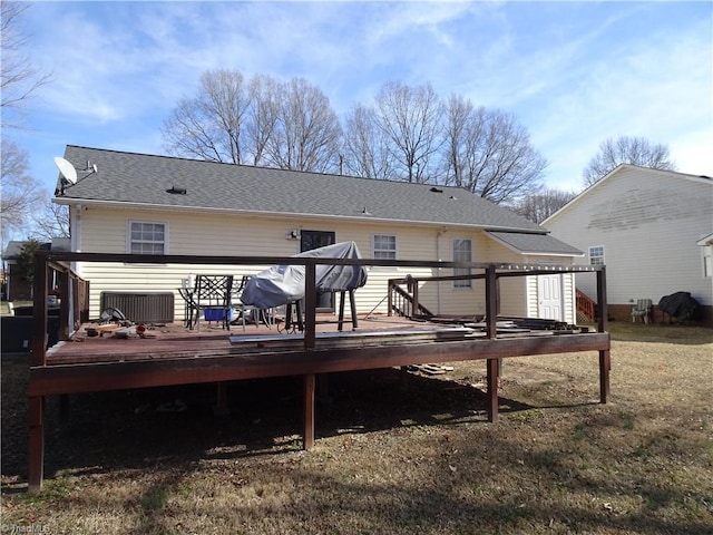 back of property with central AC, a yard, and a deck