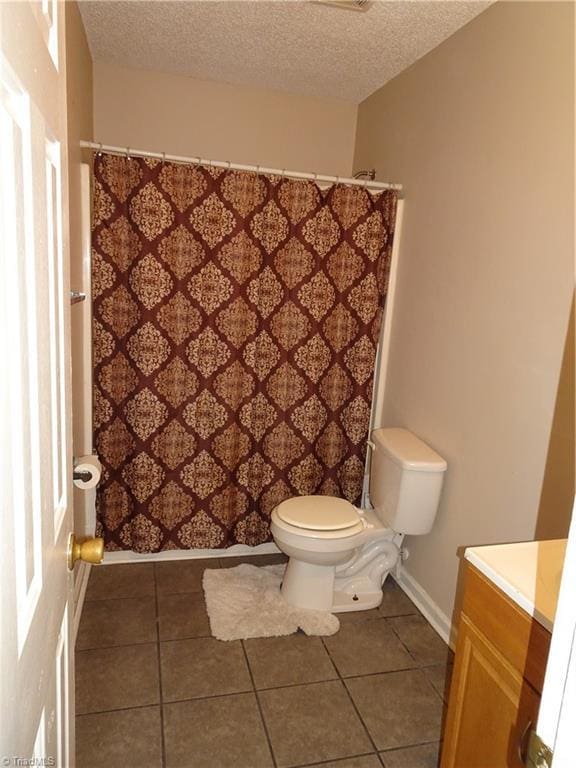 bathroom featuring vanity, a textured ceiling, tile patterned floors, and toilet