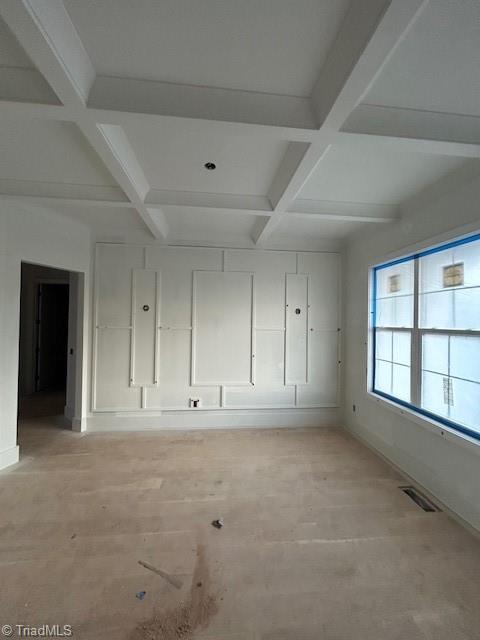 empty room with beamed ceiling, visible vents, and coffered ceiling