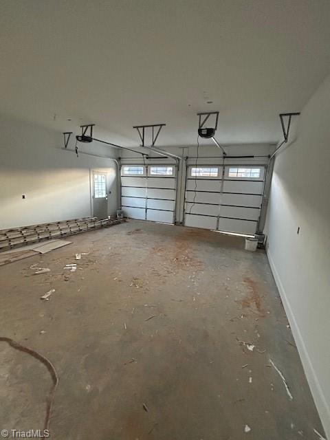 garage with a garage door opener and baseboards