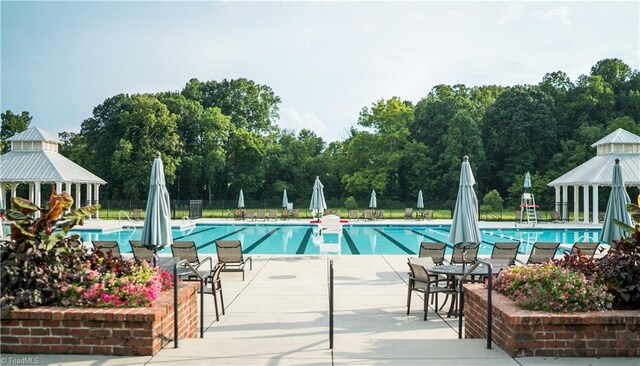 pool featuring a gazebo, fence, and a patio area