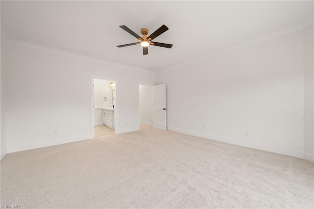 unfurnished bedroom with baseboards, light colored carpet, ornamental molding, and ensuite bathroom