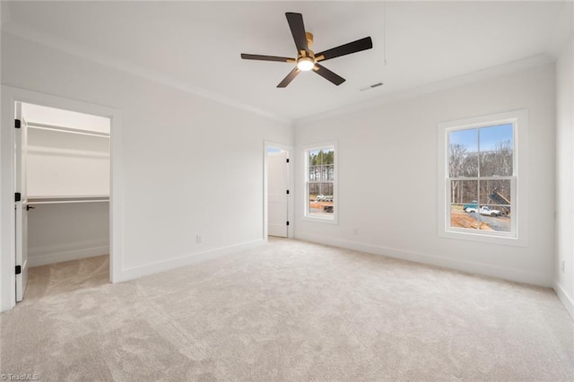 unfurnished bedroom with visible vents, light carpet, baseboards, and crown molding