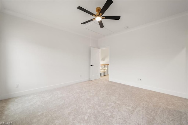 spare room with baseboards, attic access, carpet flooring, and crown molding