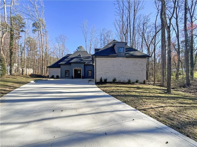 view of side of home with driveway and brick siding