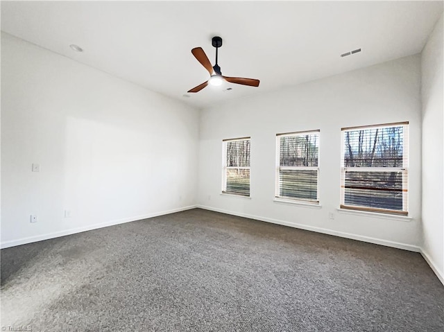 unfurnished room with dark carpet, baseboards, and ceiling fan